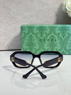 Gucci square sunglasses with dark frame, dark tinted lenses, and gold logo temples