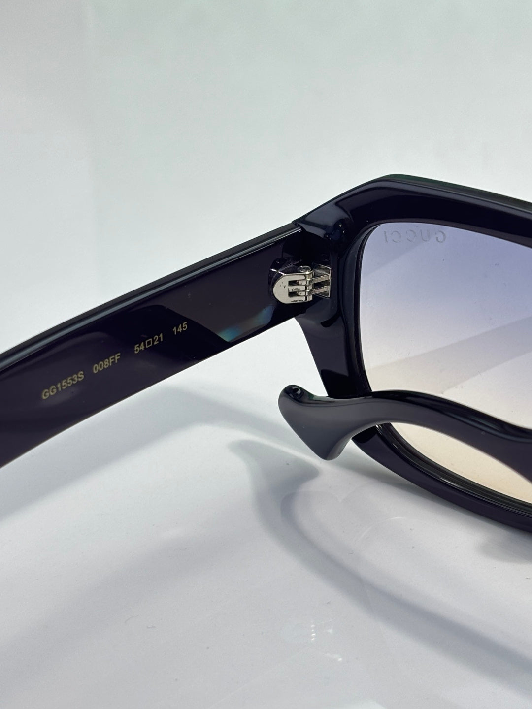 Gucci sunglasses close-up of dark temple and tinted lens
