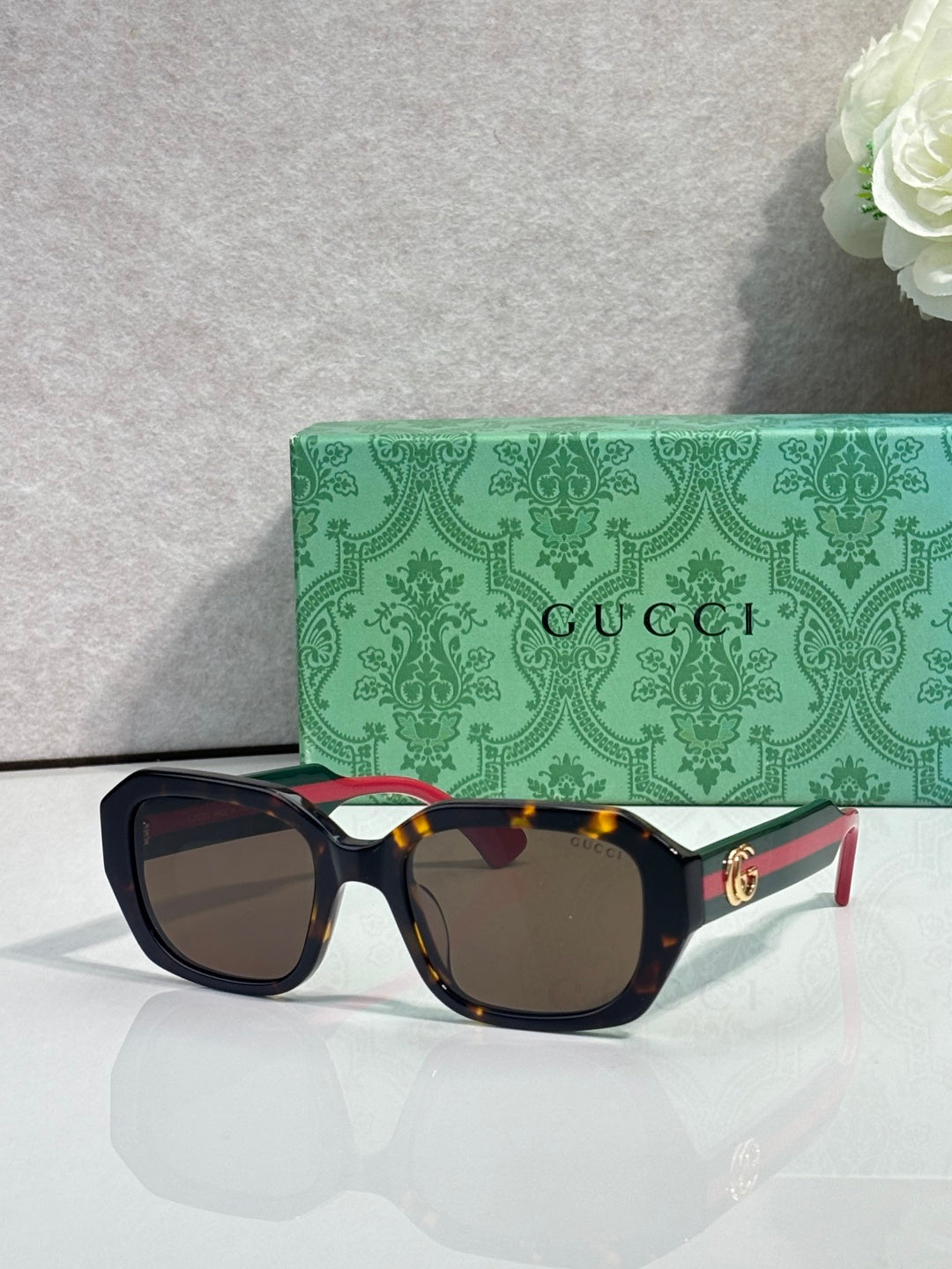 Gucci square sunglasses with dark frame, polarized-style dark lenses, gold logo temples