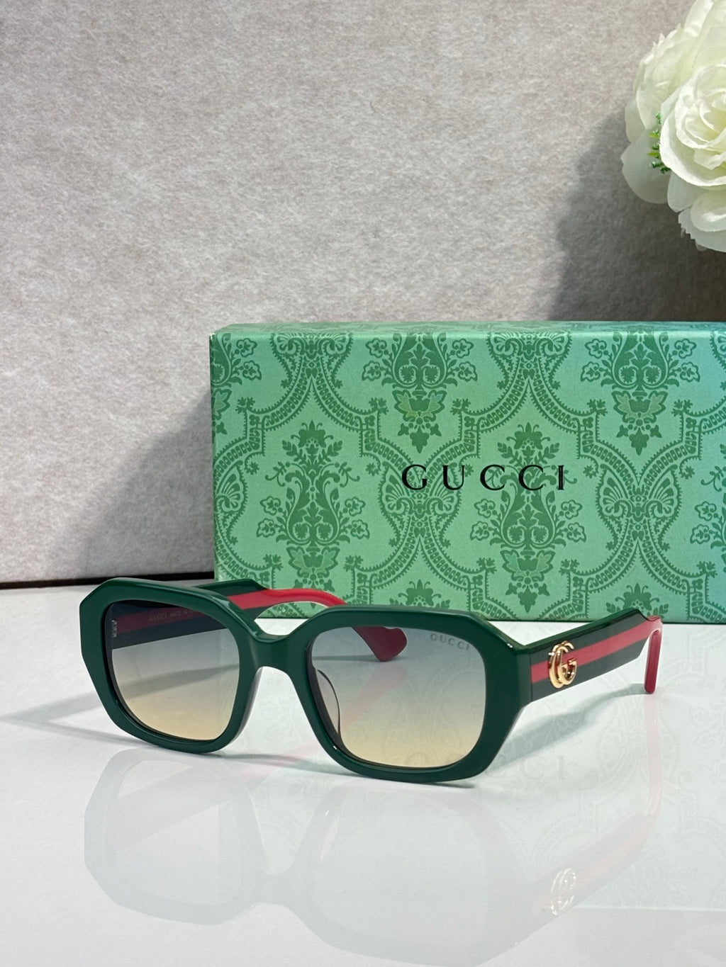Gucci square sunglasses with dark frame, light gradient lenses, and gold logo on temples