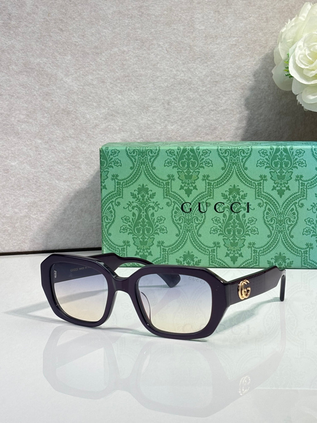 Gucci square sunglasses with dark frame and clear-to-dark gradient lenses, gold logo temples