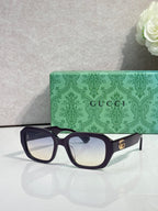 Gucci square sunglasses with dark frame and clear-to-dark gradient lenses, gold logo temples