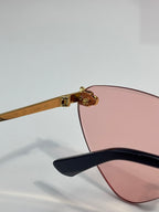 Cartier gold eyeglasses with black temple tips and pink-tinted lenses, side view