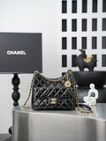 Quilted Chanel bag with gold chain strap and curved top handle, black leather finish