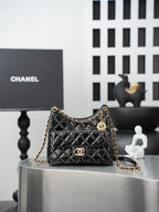 Quilted Chanel bag with gold chain strap and curved top handle, black leather finish