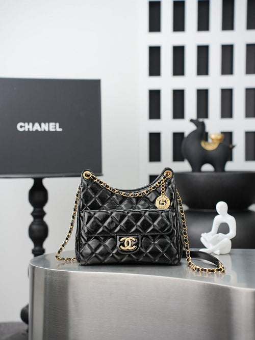 Quilted Chanel bag with gold chain strap and curved top handle, black leather finish
