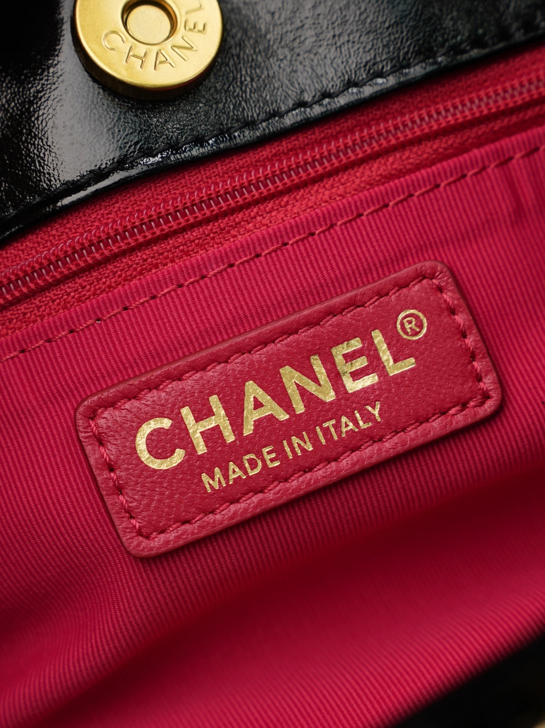 Chanel label reading 'MADE IN ITALY' on burgundy fabric interior lining