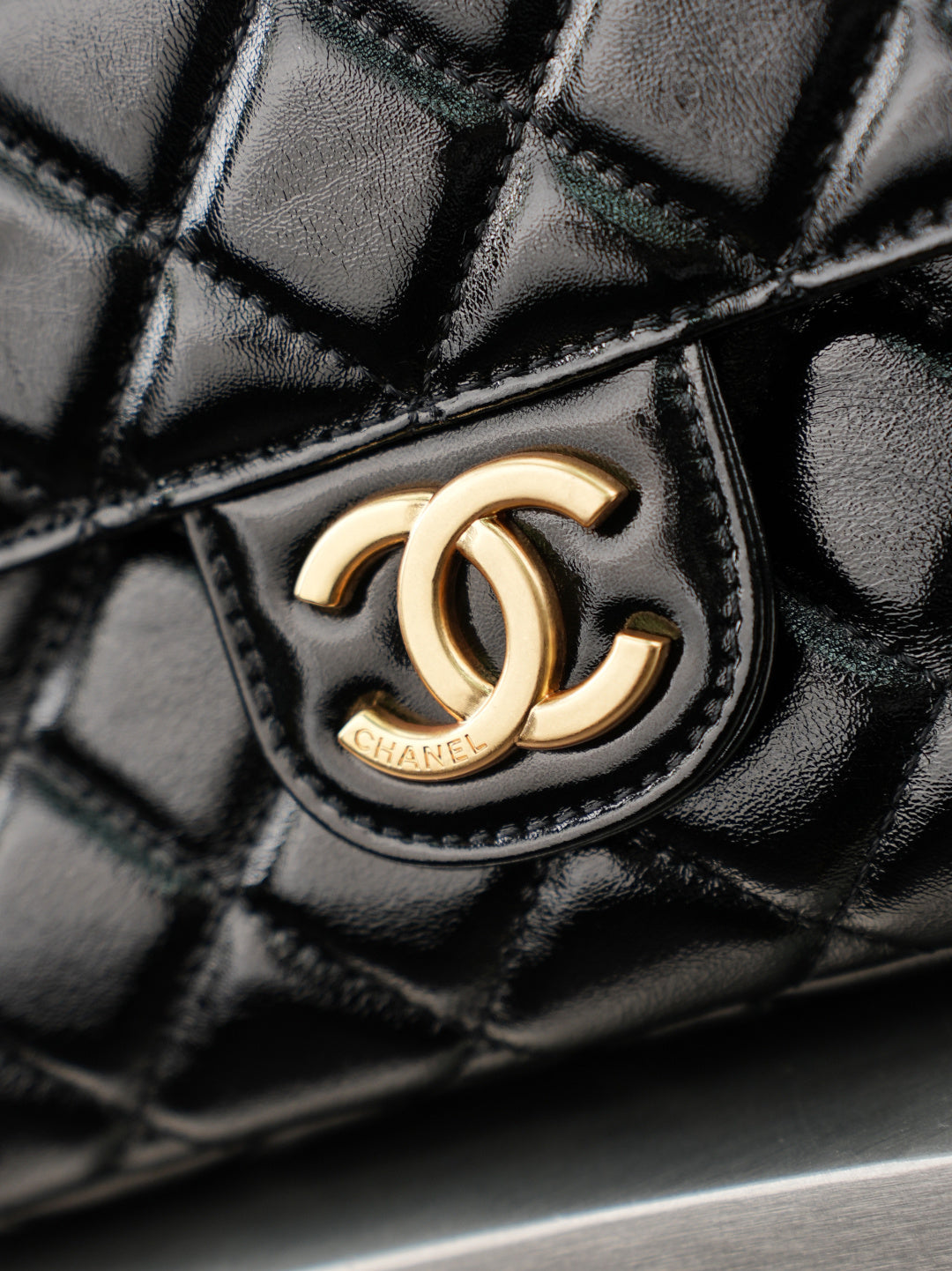 Chanel CC logo on quilted black leather bag with gold-tone emblem