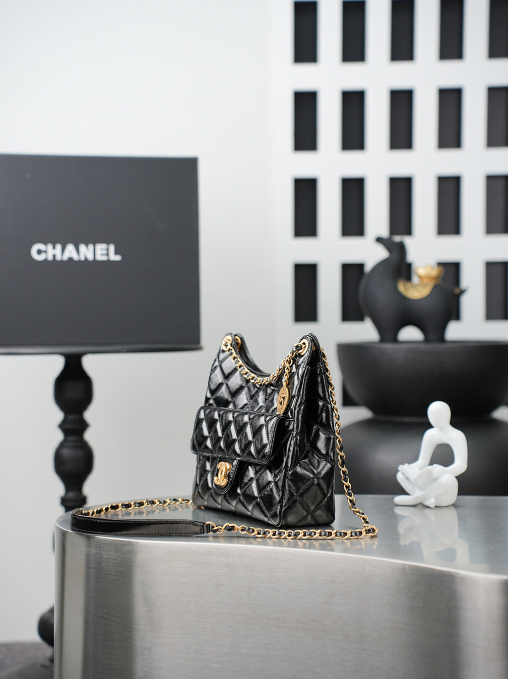 Quilted Chanel bag with gold chain strap, small top handle, black leather exterior