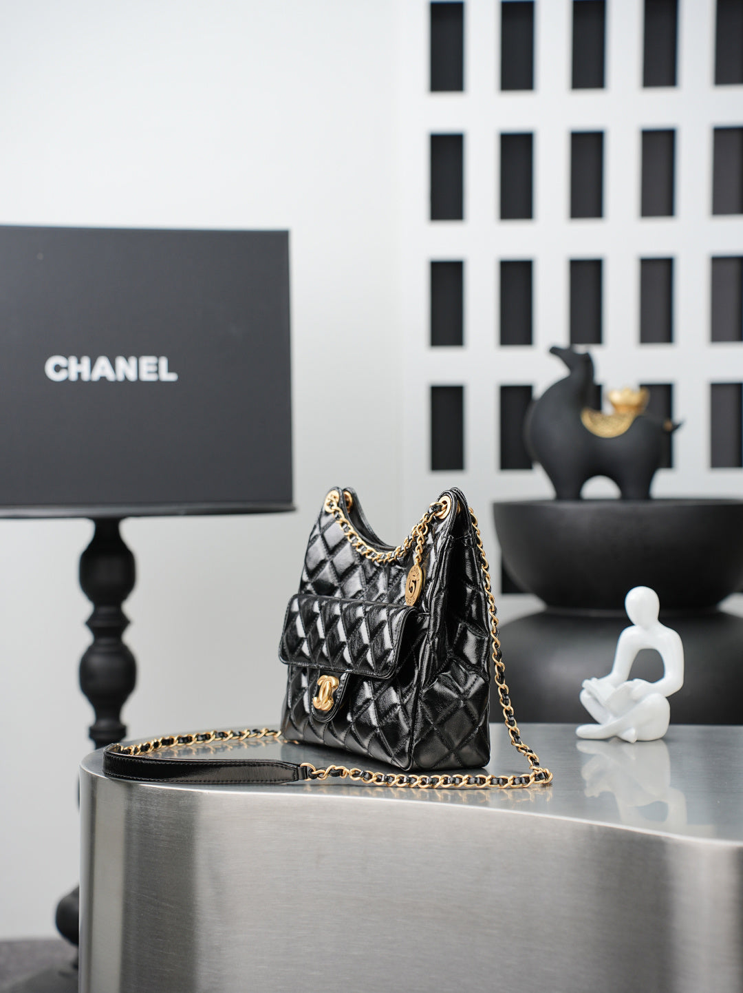 Quilted Chanel bag with gold chain strap, small top handle, black leather exterior