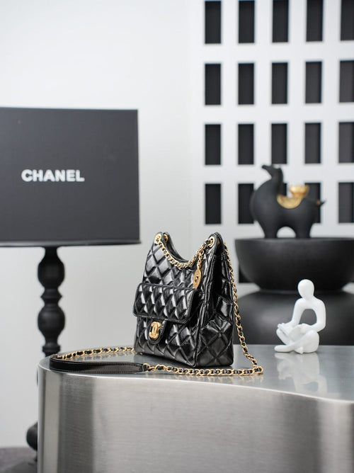 Quilted Chanel bag with gold chain strap, small top handle, black leather exterior