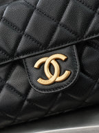 Chanel CC logo on quilted dark leather bag front with gold-tone emblem