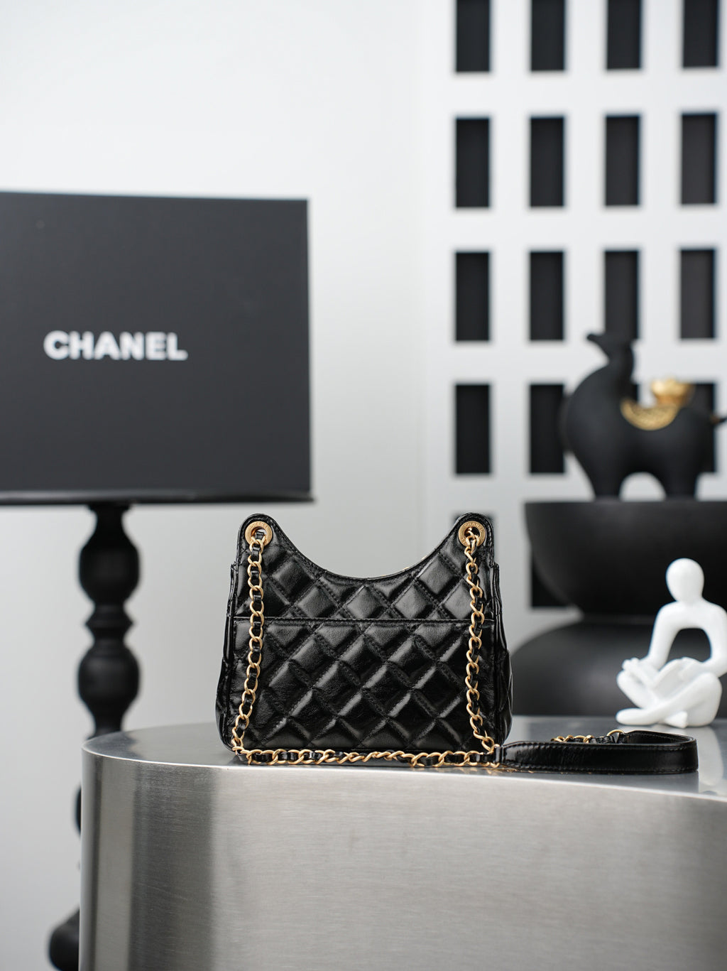 Chanel quilted black mini bag on display with gold chain strap and CC hardware