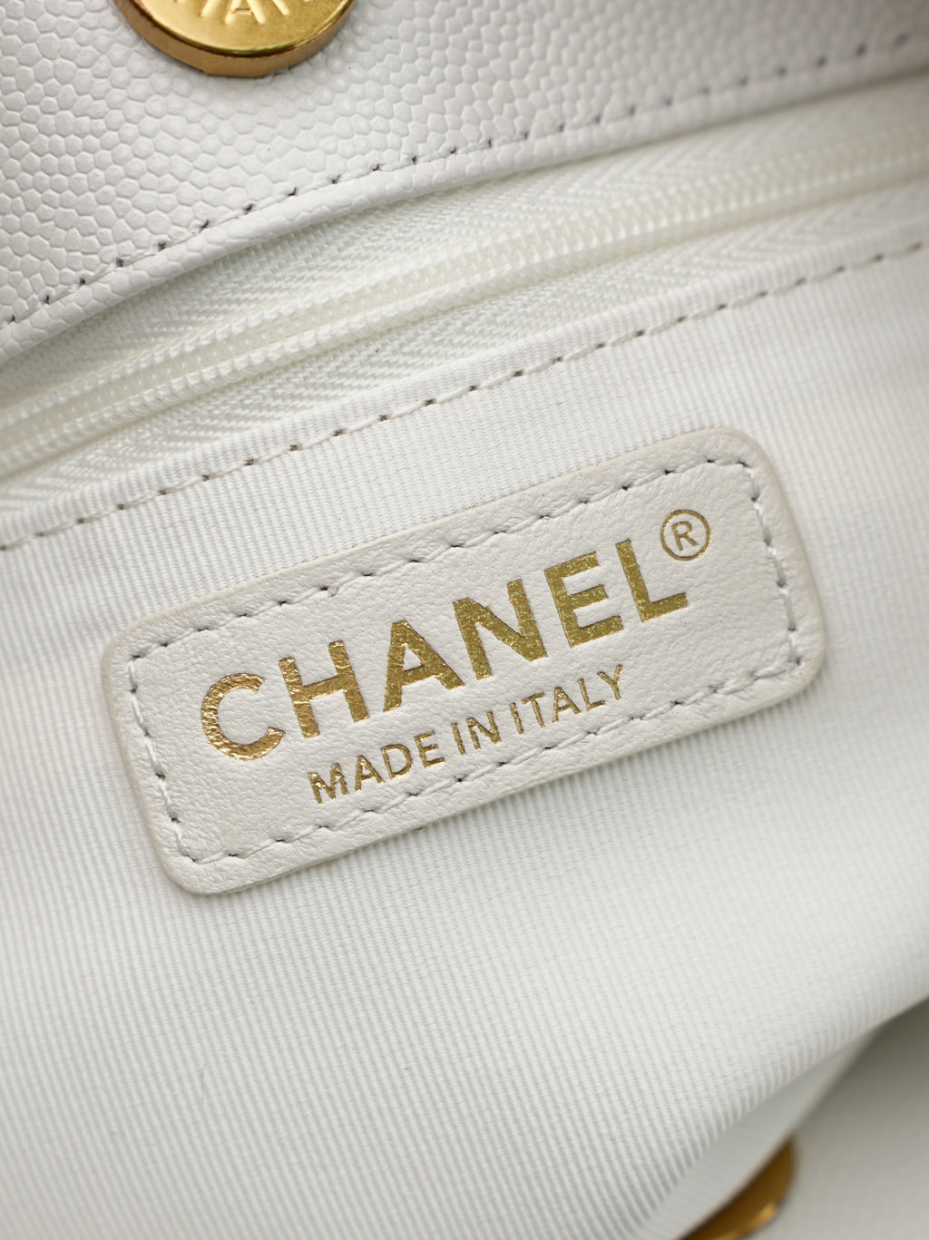 Chanel Made in Italy label on white leather bag with gold chain hardware
