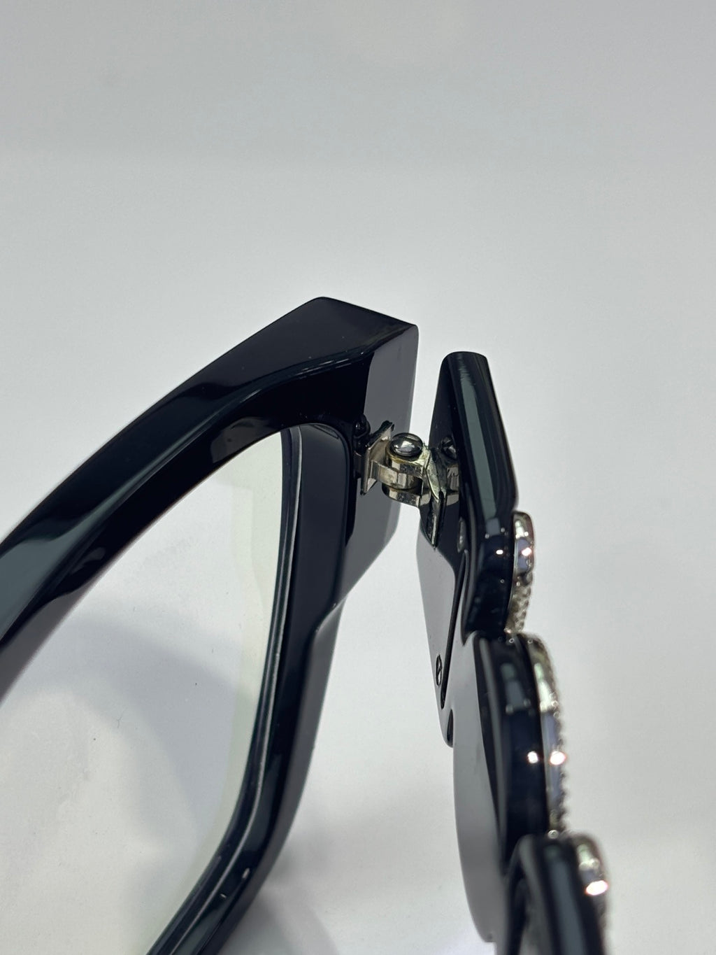 Black eyeglasses temple close-up with metallic hinge detail