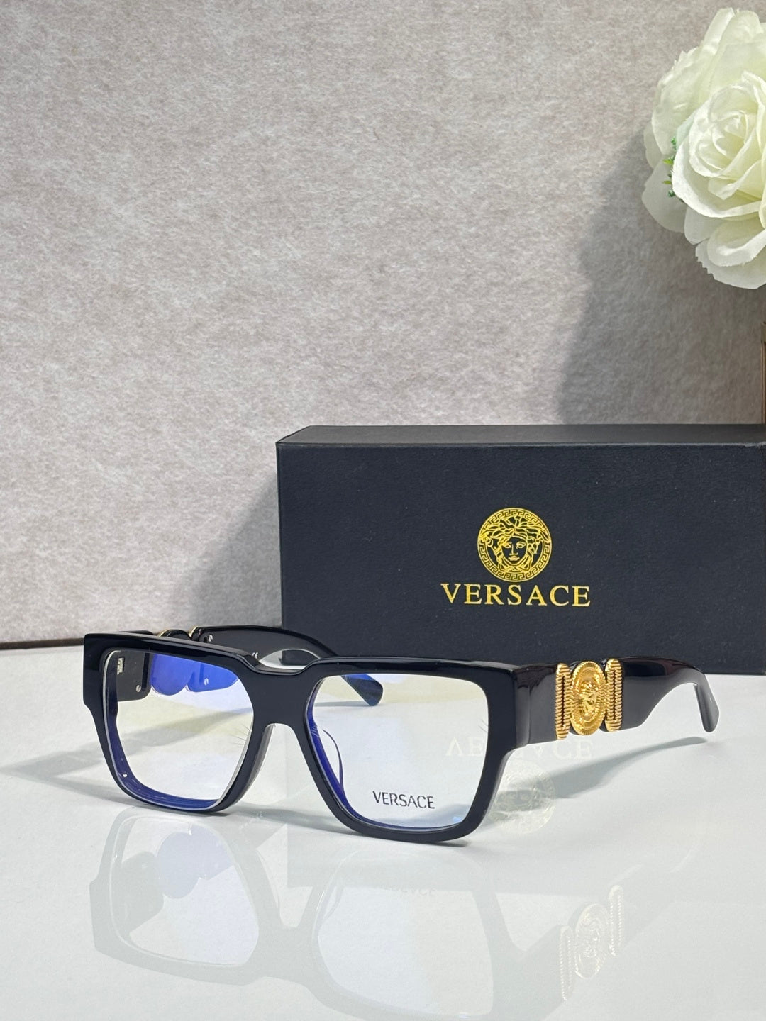 Versace eyeglasses with dark blue frames and clear lenses with gold temple emblem