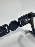 Black eyeglasses close-up of frame and lens rim with metallic hardware