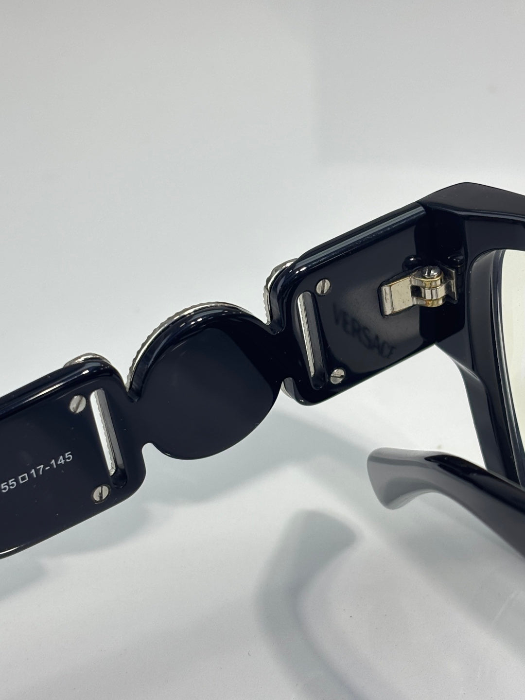 Black eyeglasses close-up of frame and lens rim with metallic hardware