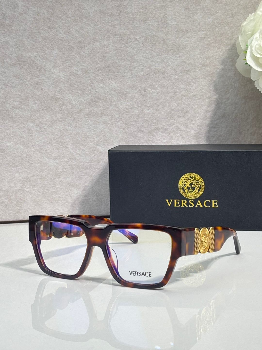 Versace eyeglasses with tortoise frames, clear lenses, and metallic temple emblem