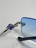 Eyeglasses close-up: blue crystal temple detail, gold-tone hinge, blue arms