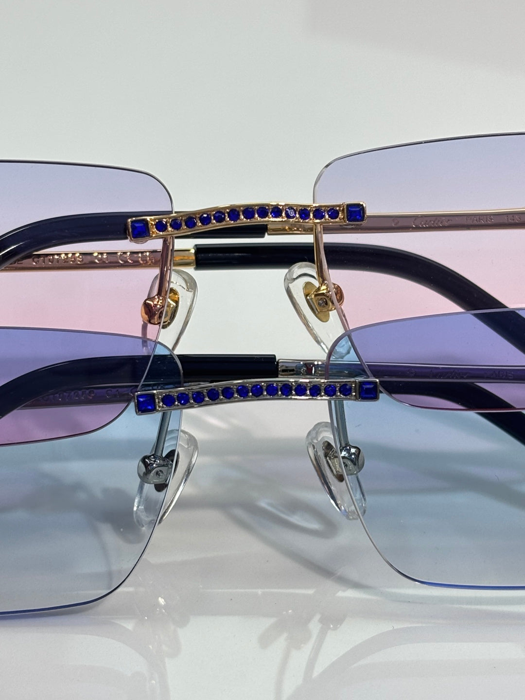Cartier eyeglasses close-up of bridge with blue crystals on dark frames.