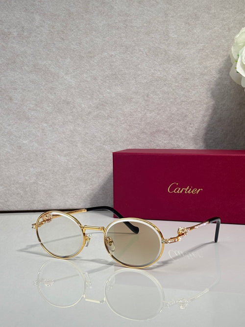 Round sunglasses with gold-tone frame, gray lenses, and black temples