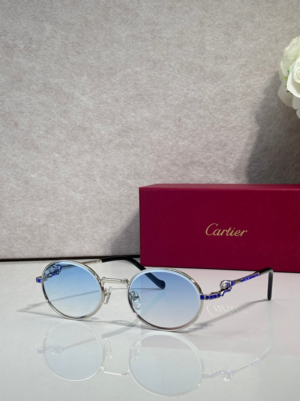 Cartier round eyeglasses with silver frame, light blue tinted lenses, black accents