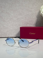 Cartier round eyeglasses with silver frame, light blue tinted lenses, black accents