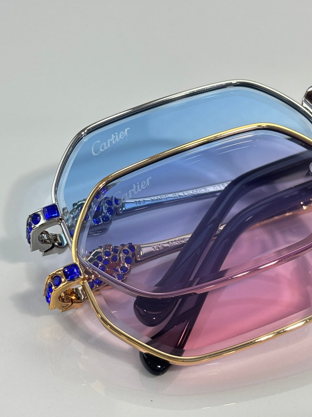 Cartier eyeglasses close-up with blue gemstone accents on gold frame, tinted lenses