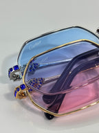 Cartier eyeglasses close-up with blue gemstone accents on gold frame, tinted lenses