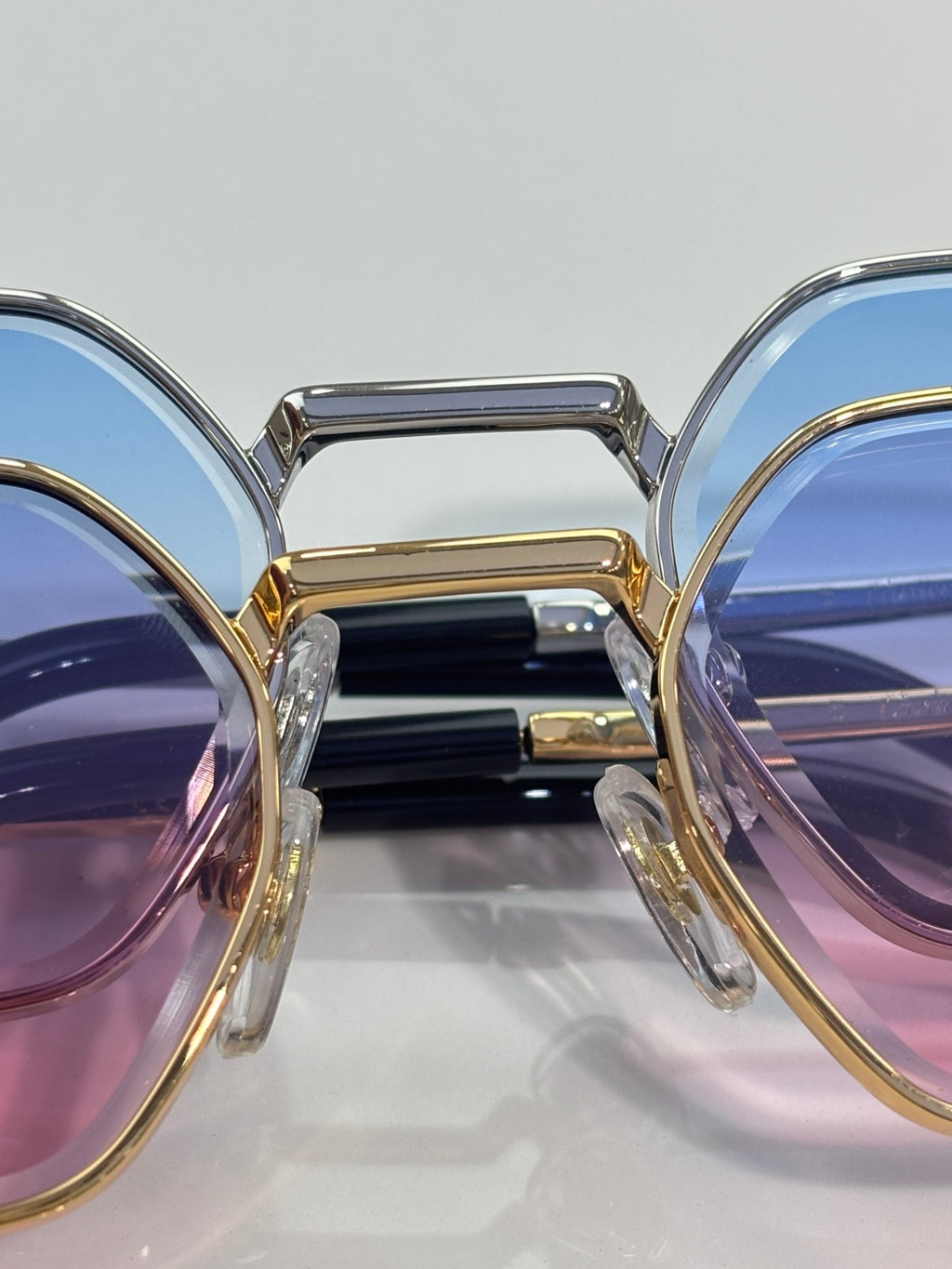 Cartier eyeglasses close-up with gold/silver frames and blue-purple tinted lenses