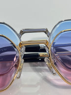 Cartier eyeglasses close-up with gold/silver frames and blue-purple tinted lenses
