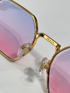Cartier eyeglasses close-up with gold frame, tinted lenses, and engraved temple markings.