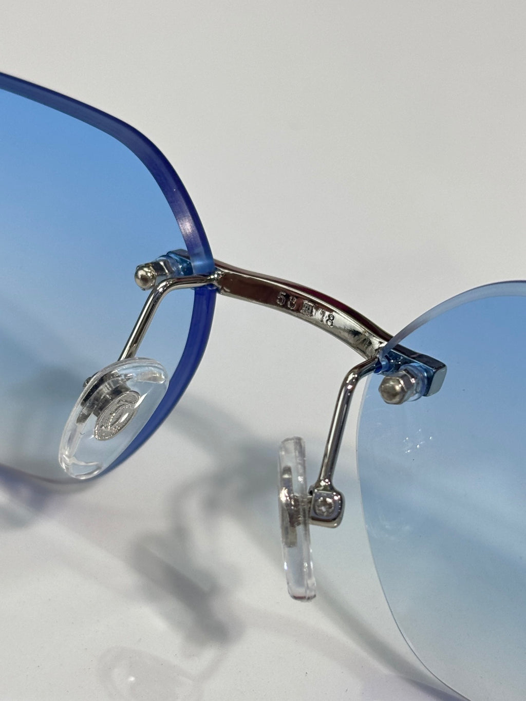 Cartier eyeglasses close-up: blue temple with metal hinge and clear light lenses