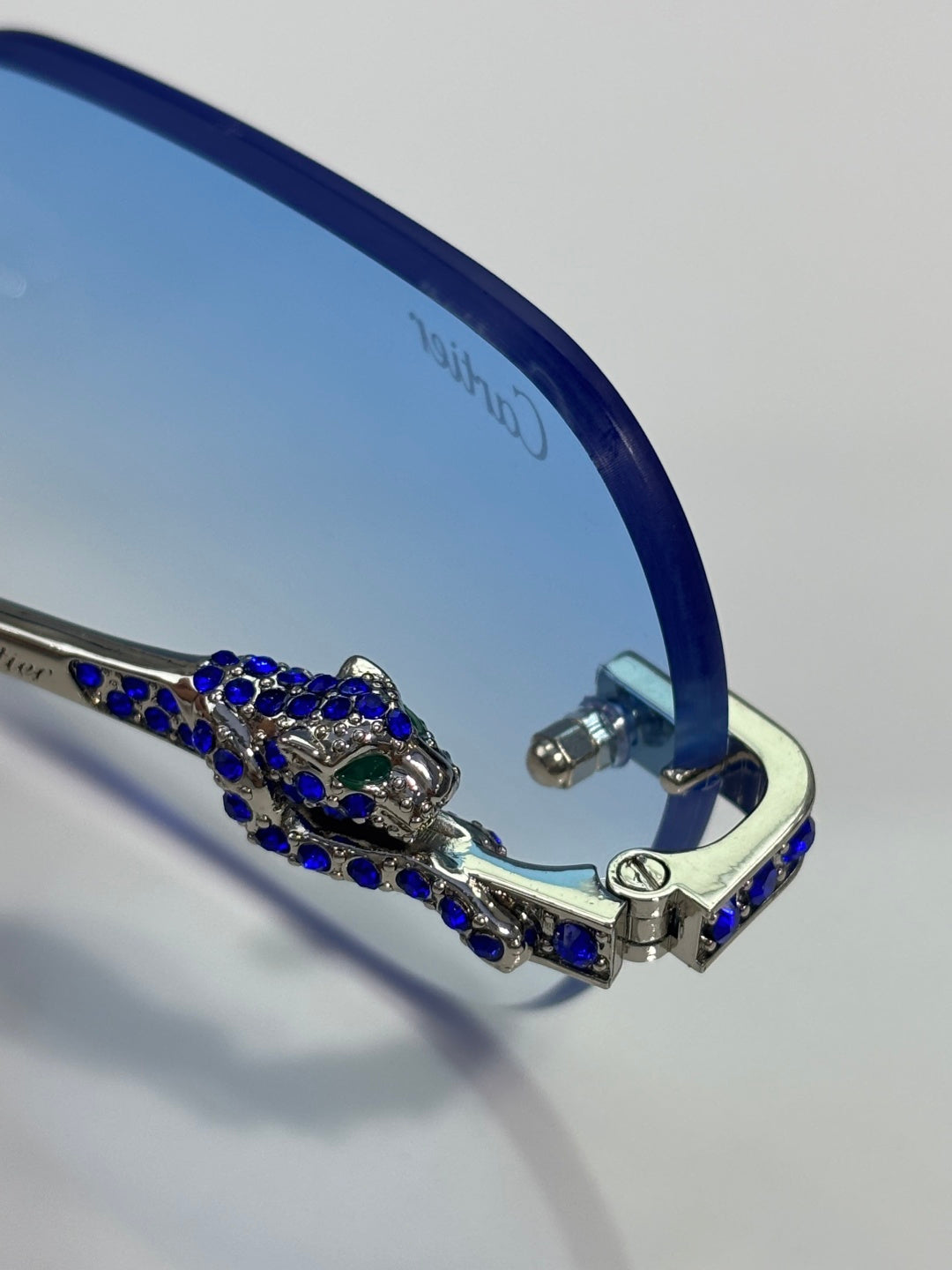 Cartier eyeglasses close-up: blue temple with ornate rhinestone bar and gold hinge