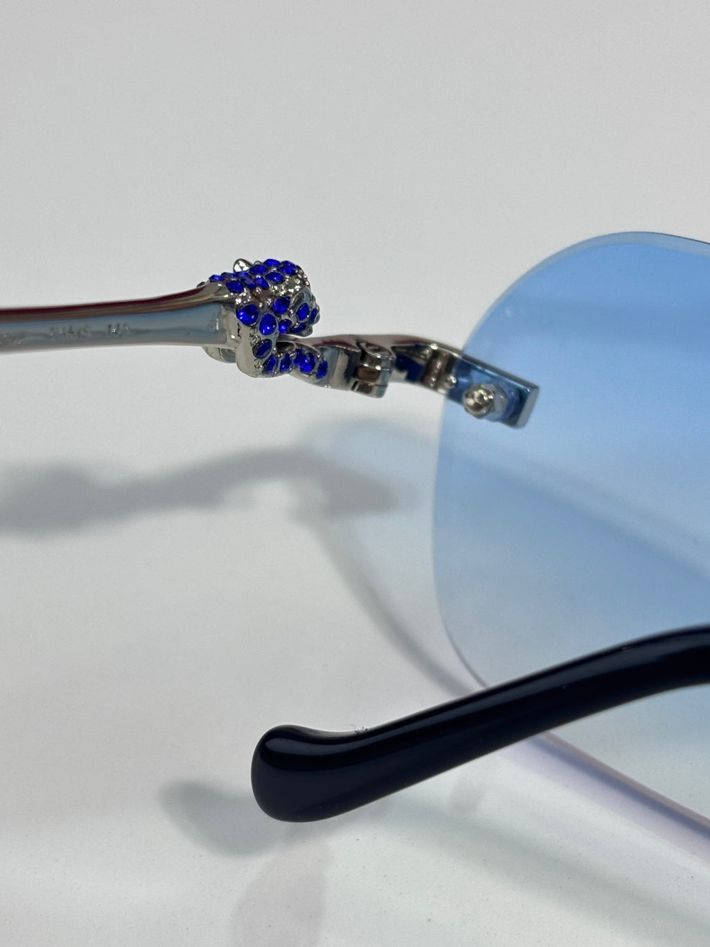 Cartier eyeglasses close-up: blue-tinted lens, jeweled temple end and black temple tip