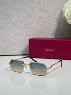 Gold-tone eyeglasses with green-tinted lenses and ornate temple motifs