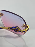 Purple-pink gradient eyeglass lens with blue jewel bridge and gold decorative arm