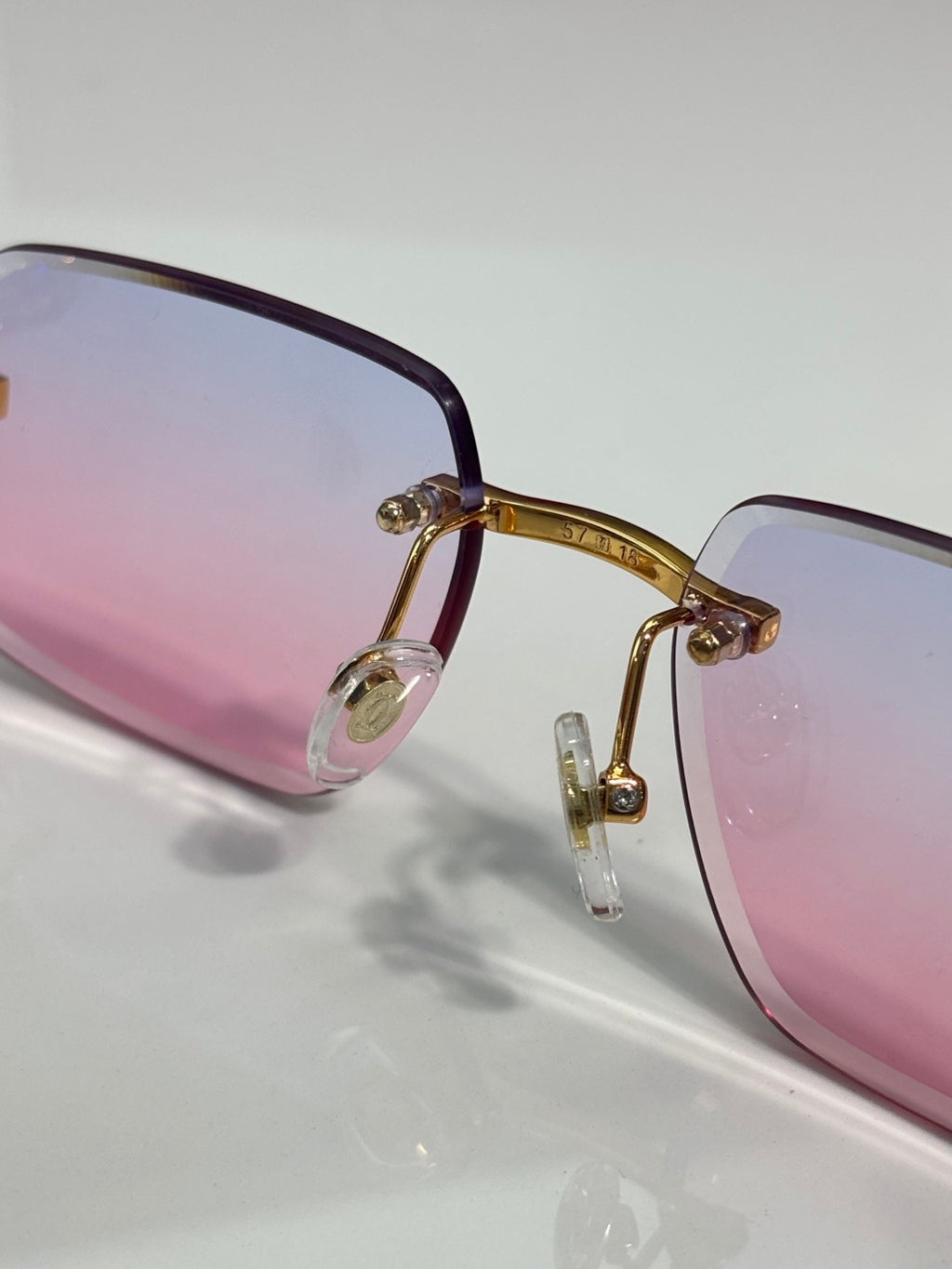Pink gradient eyeglass frame with clear nose pads and gold-toned metal bridge