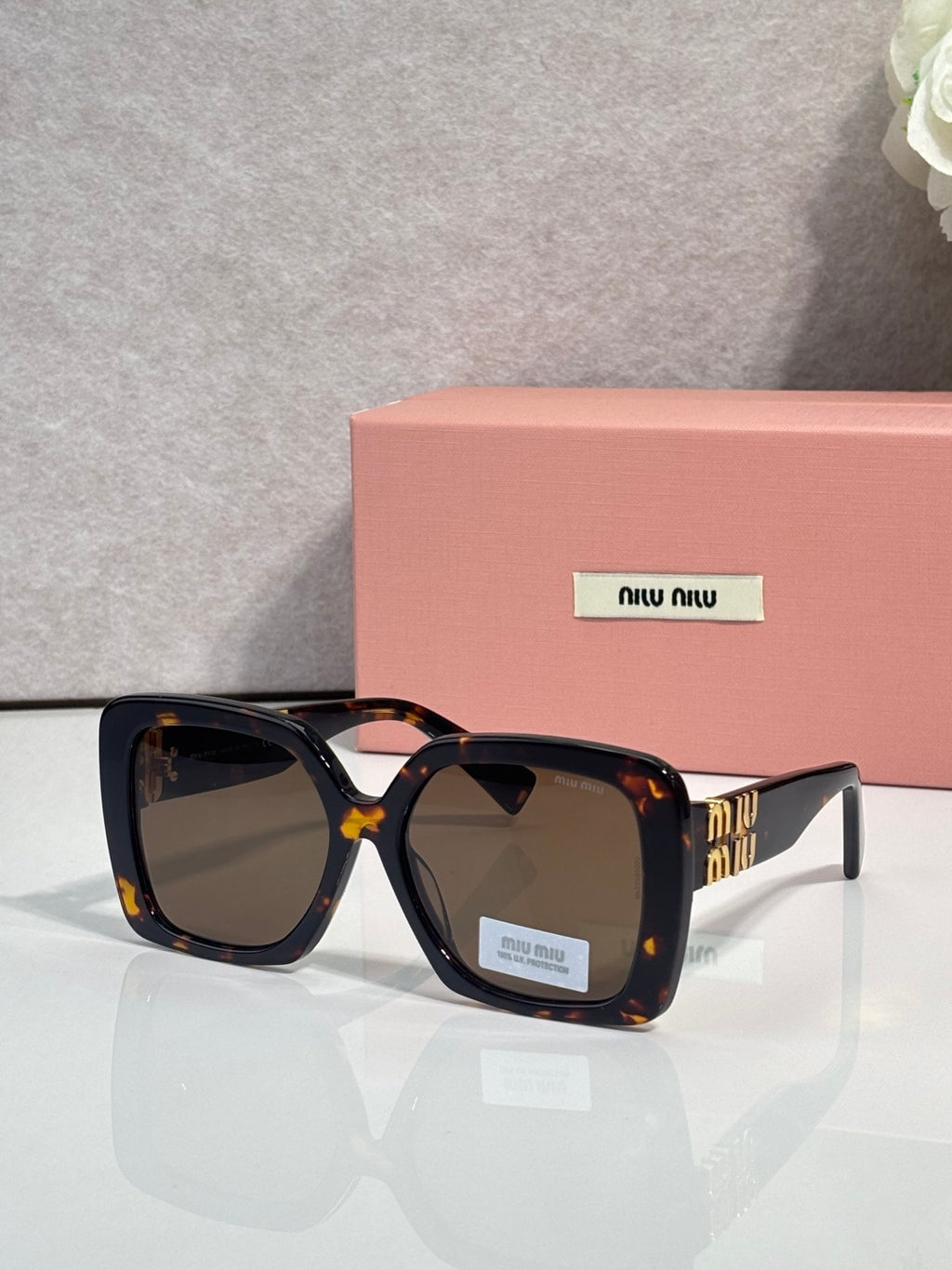 MiuMiu square sunglasses with dark lenses, tortoiseshell frame, gold temple detail