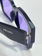Black sunglasses with Prada logo on temple, metal hinge detail