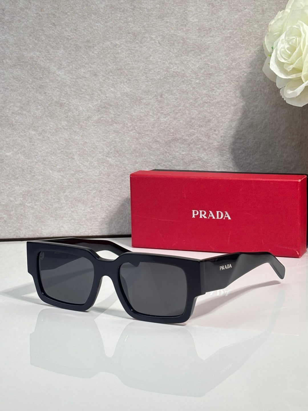 Black sunglasses with dark lenses and Prada logo on temple