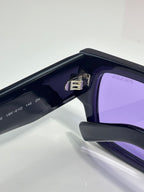 Black sunglasses with purple lenses, hinge detail on side temple