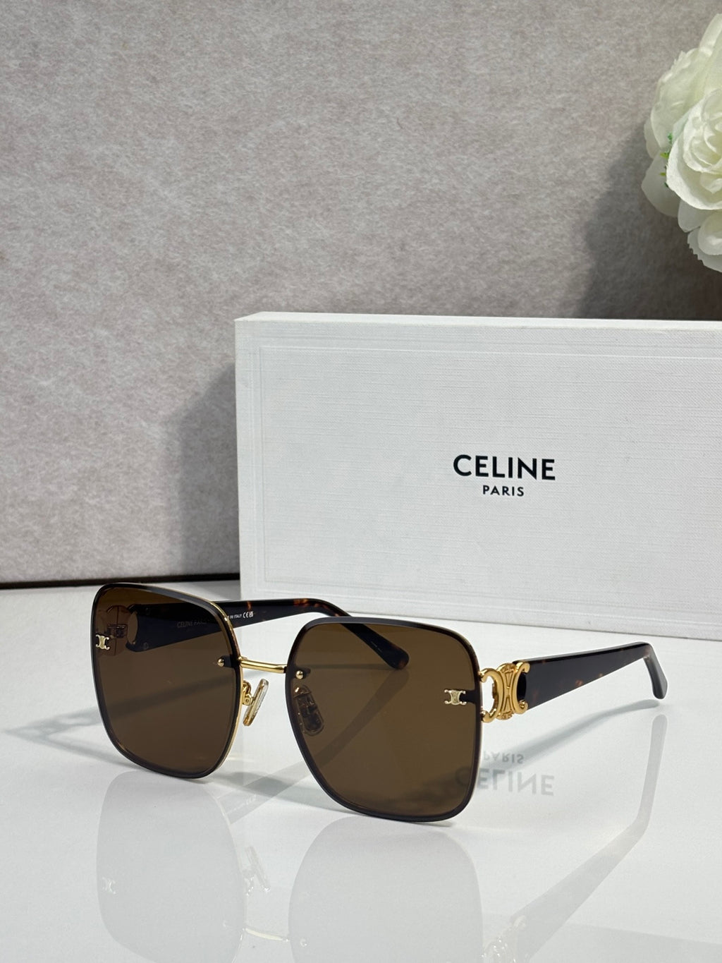 Celine sunglasses with dark frames, gold accents, and brown tinted lenses.