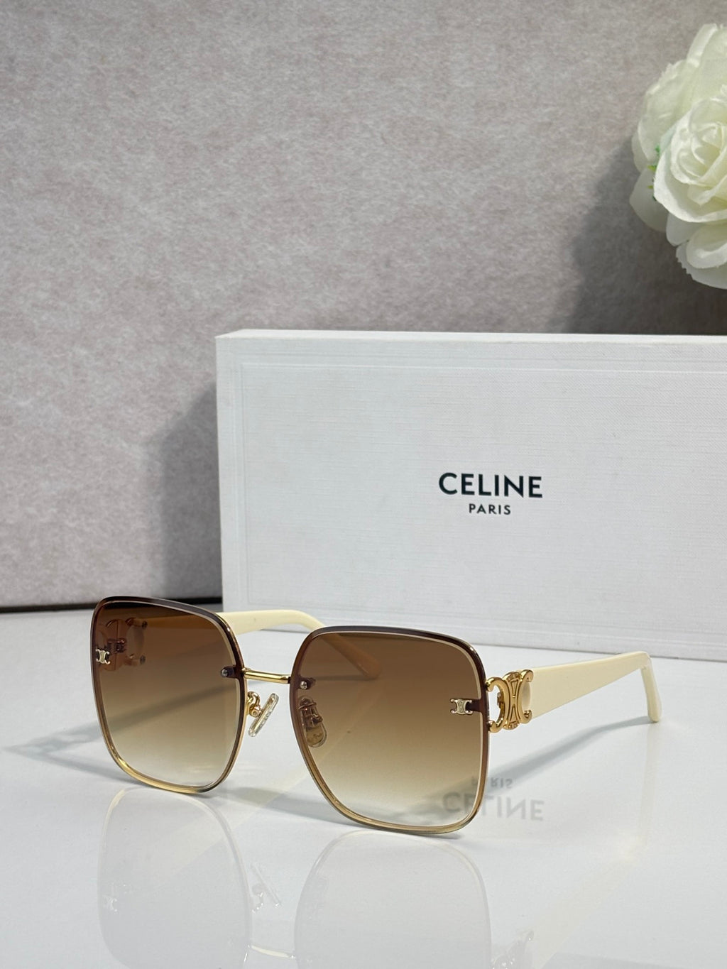 Celine sunglasses with light brown frames, gold accents, and amber tinted lenses.