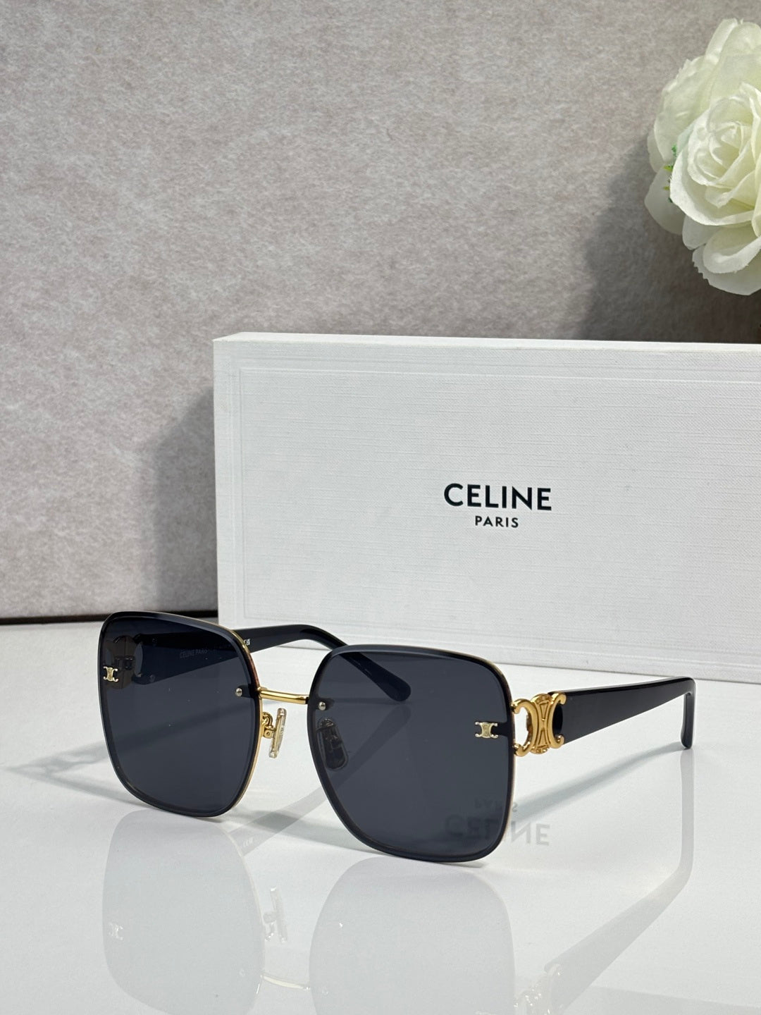 Celine sunglasses with navy-black frames, gold accents, and dark tinted lenses.