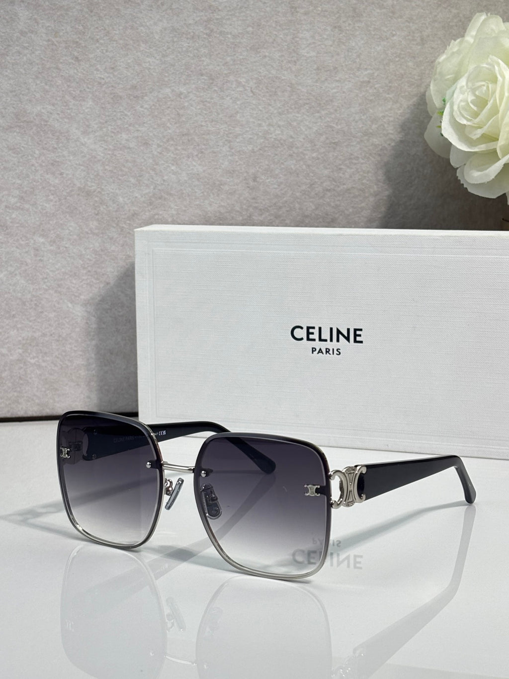 Celine sunglasses with black frames, gold accents, and dark tinted lenses.
