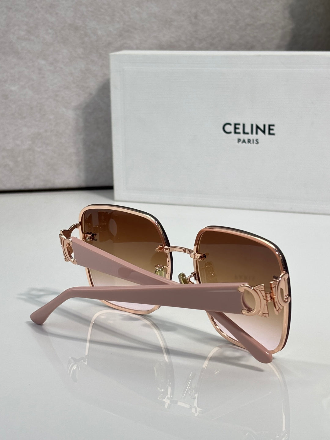 Celine sunglasses with rose pink frames, gold accents, and brown tinted lenses.