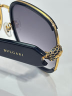 Sunglasses side close-up: gold patterned temple and BVLGARI branding on arm