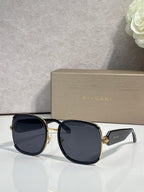 Round sunglasses with dark navy frame, gold accents, blue tinted lenses